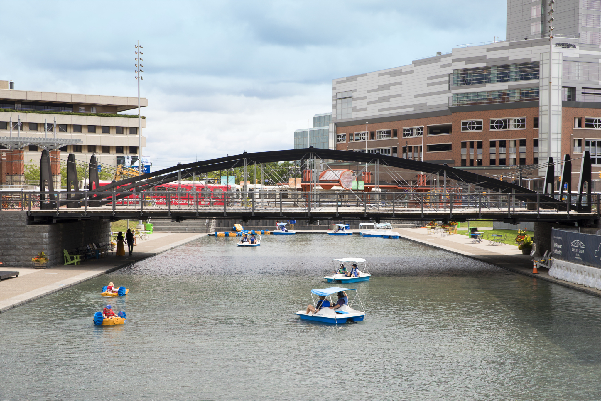 People Pedal Boating Underneath Bridge